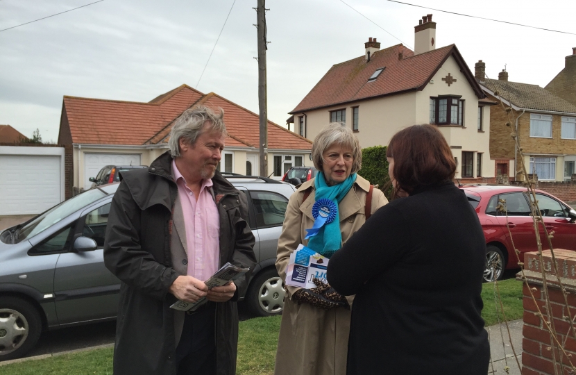 Giles Watling and Theresa May speak with a resident