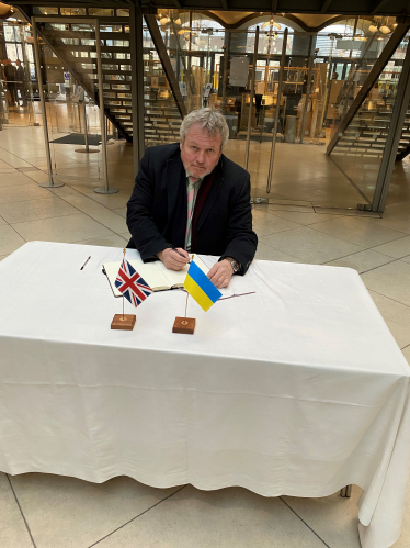 Giles signing the book to Ukraine